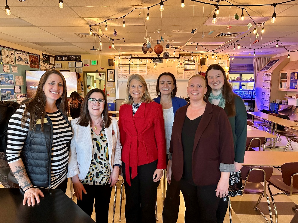 A group of women standing in a roomAI-generated content may be incorrect.